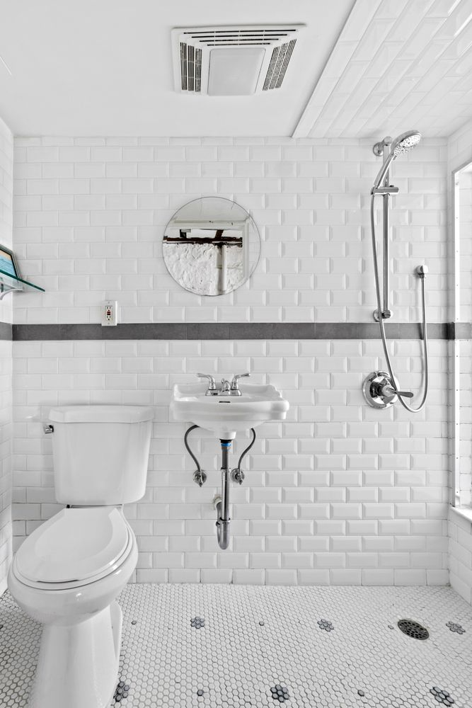 bath with white fixtures, open shower