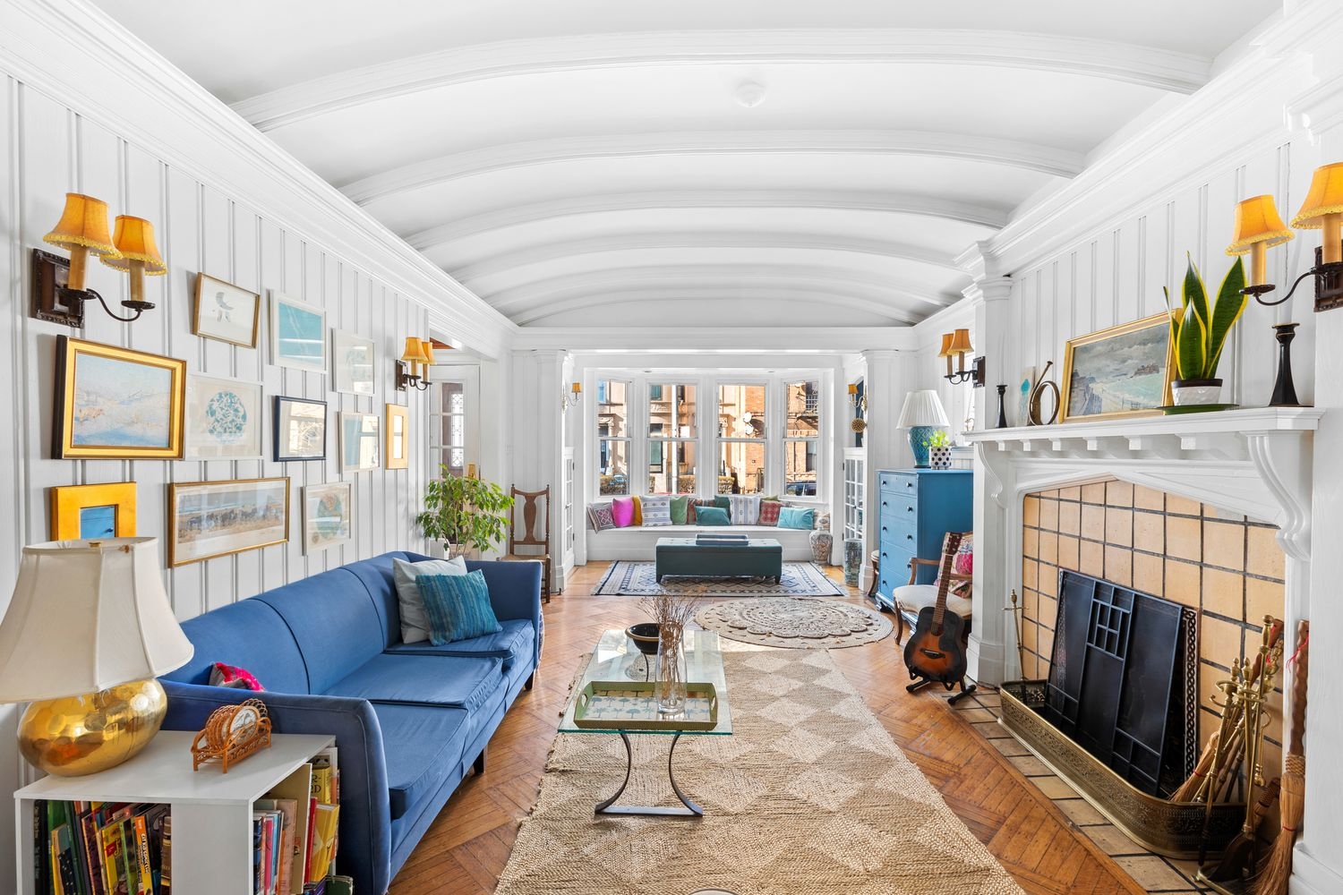 parlor with paneling, mantel, window seat