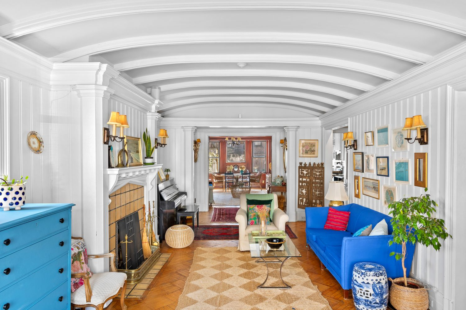 parlor with paneling, mantel, wood floor