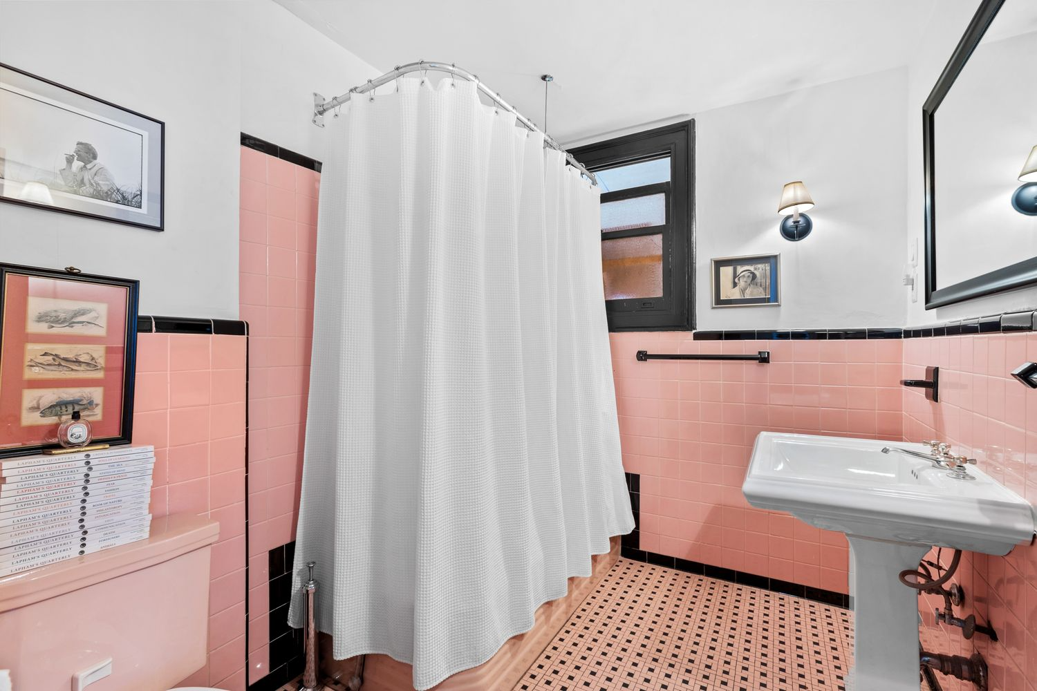 bathroom with pink tub, toilet and tile