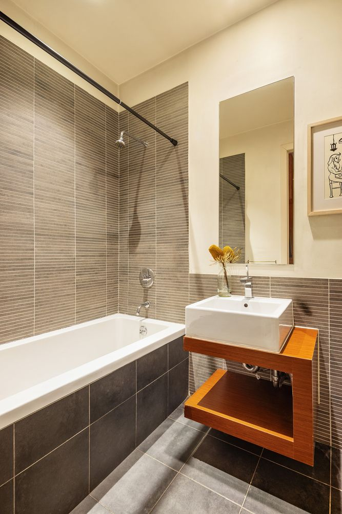 bathroom with beige tile, floating vanity