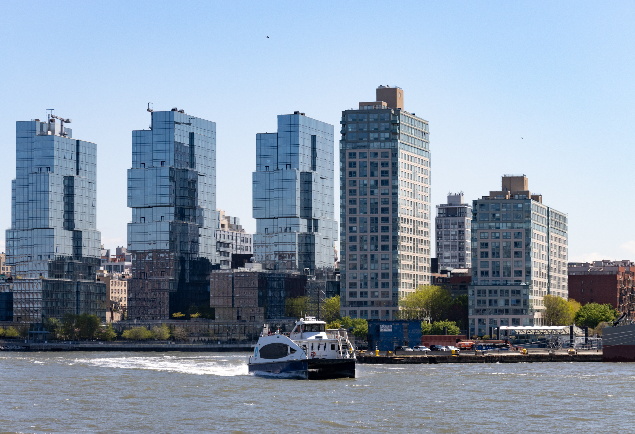 brooklyn - a ferry in the water with glassy towers behind it
