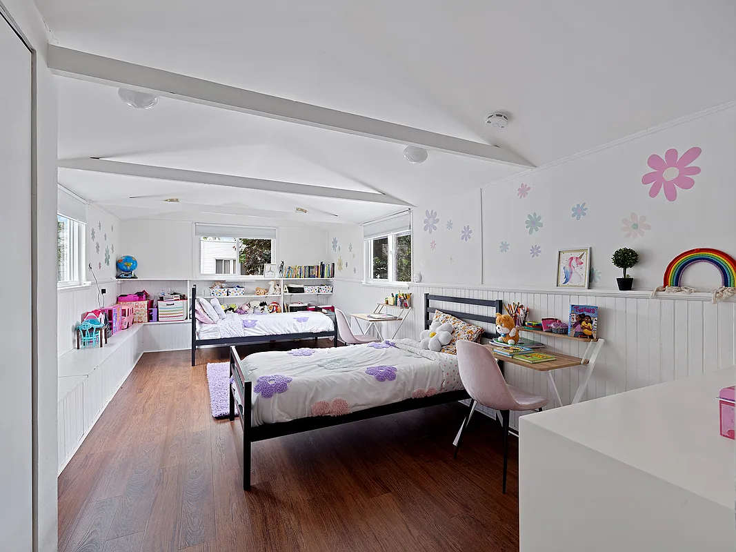 sleeping porch set up as a child's bedroom with flower decals on the walls