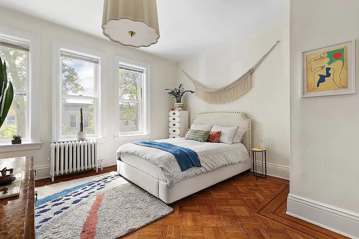 bedroom with white walls, wood floor