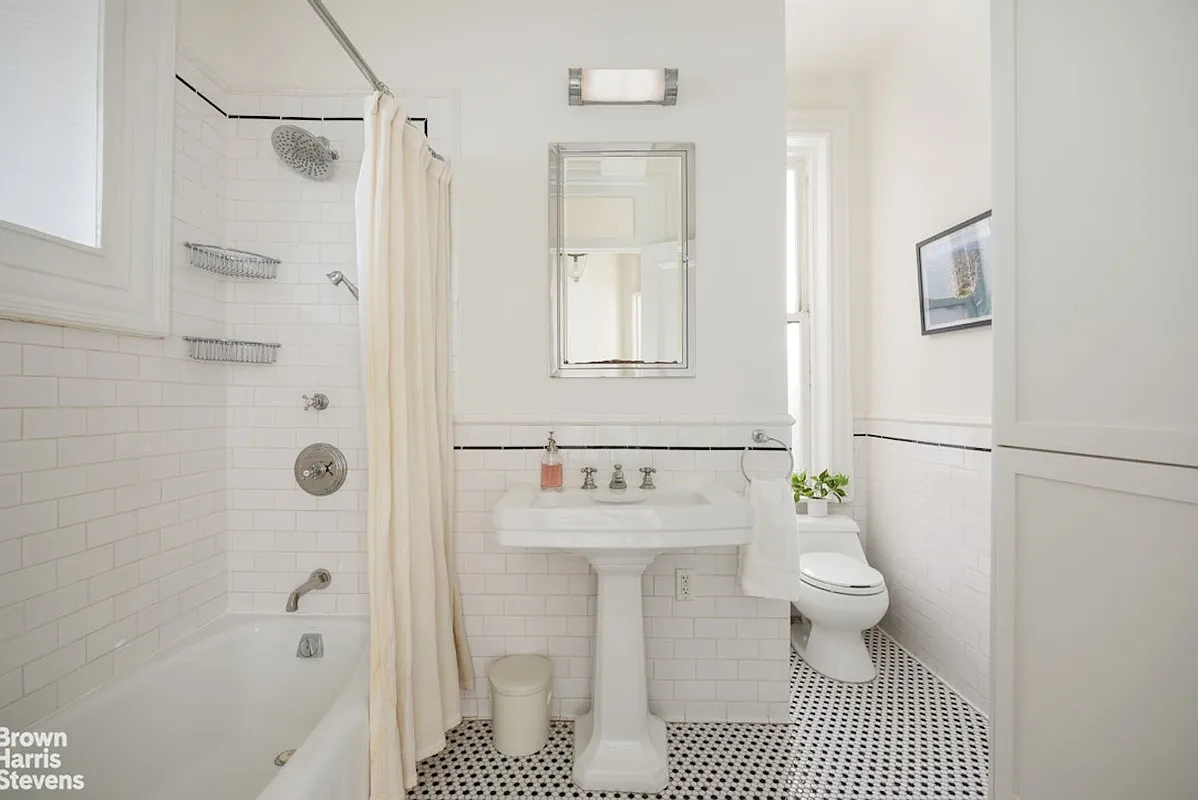 bathroom with white fixtures, black and white floor tile