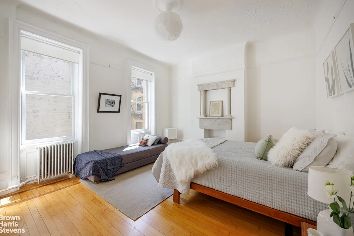 bedroom with white walls, picture rails, two windows