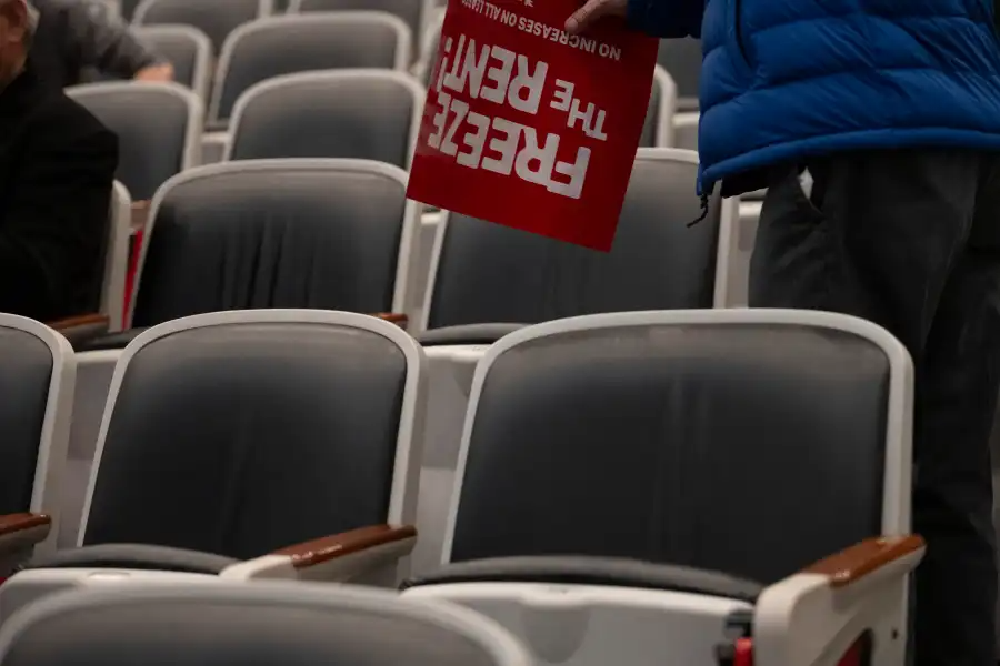 empty seats with a freeze the rent sign